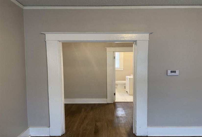 Hallway with dark wood-type flooring and ornamental molding