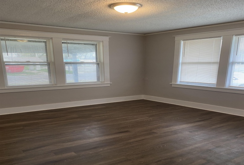 Spare room featuring dark wood finished floors and a textured ceiling