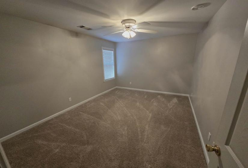 Carpeted empty room with baseboards and a ceiling fan