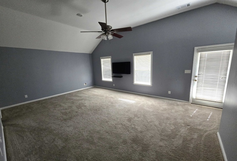 Spare room with lofted ceiling, carpet, and ceiling fan