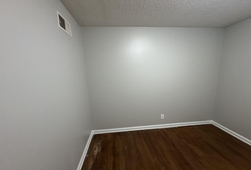 Unfurnished room featuring dark wood-style floors and a textured ceiling