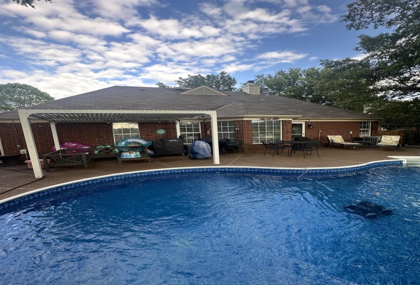 Swimming pool featuring a patio, outdoor dining area, and a pergola