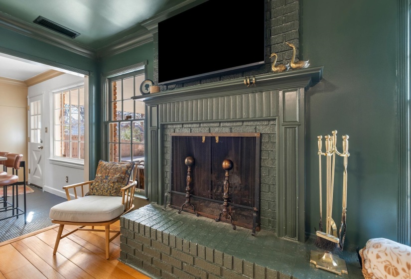Sitting room with crown molding, a fireplace, and hardwood / wood-style floors