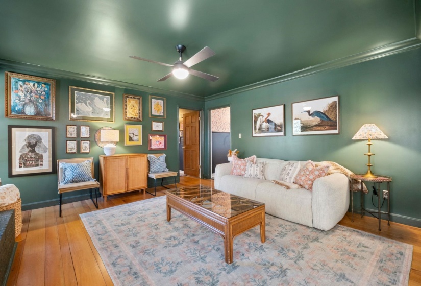 Living area featuring crown molding, hardwood / wood-style flooring, and ceiling fan
