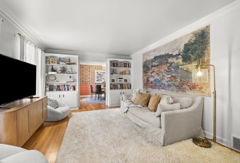 Living room featuring light wood-style flooring and crown molding