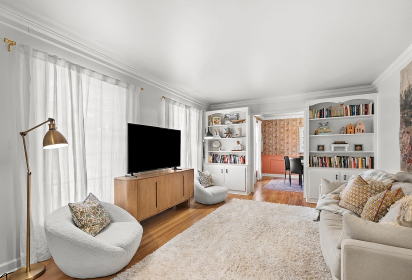 Living area featuring light wood-style floors, ornamental molding, and wallpapered walls