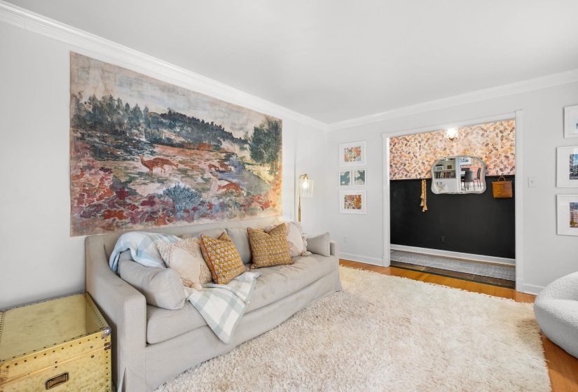 Living room with wood finished floors and ornamental molding