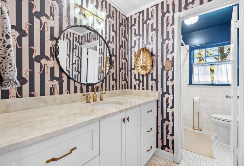 Full bathroom featuring vanity, a shower with curtain, wallpapered walls, and light tile patterned floors