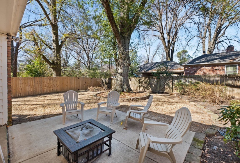 Fenced backyard with a patio area and a fire pit