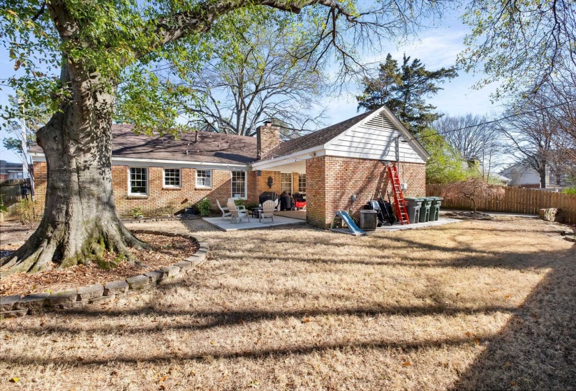 Rear view of property featuring brick siding, a patio, and a chimney