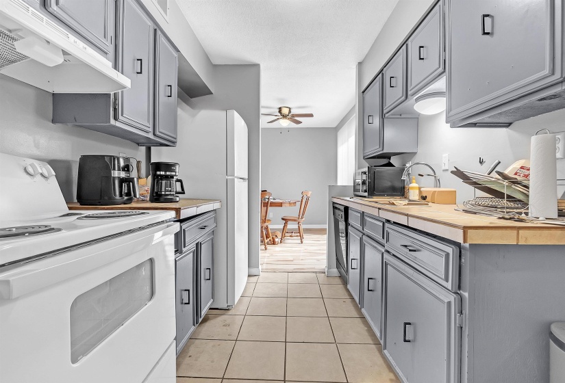 Kitchen featuring black appliances, gray cabinetry, under cabinet range hood, and a ceiling fan