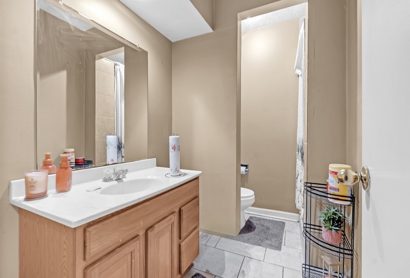 Full bathroom with vanity, curtained shower, and light tile patterned floors