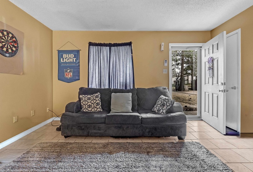 Living room with a textured ceiling and tile patterned flooring