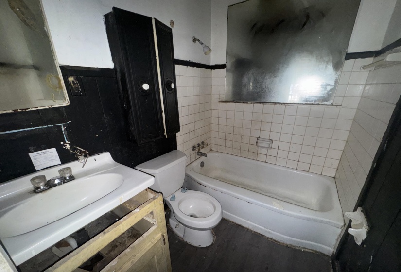 Bathroom with vanity, shower / bath combination, and dark wood-type flooring