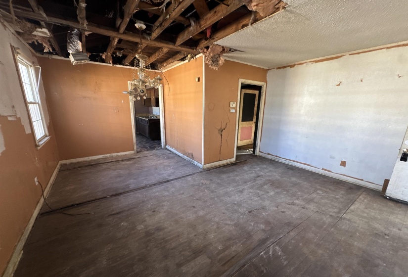 Unfurnished room featuring baseboards and a chandelier