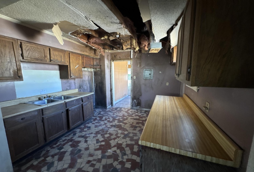 Kitchen with light countertops and dark flooring