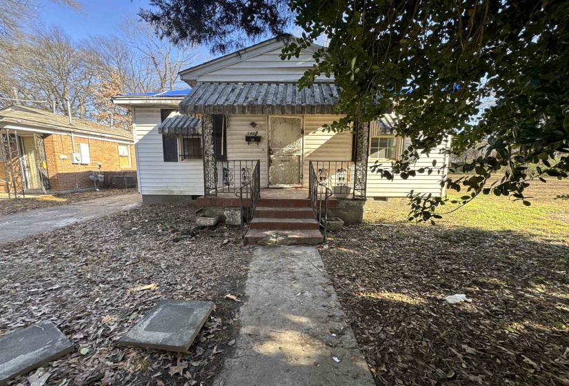 View of front facade featuring crawl space, covered porch, and a metal roof