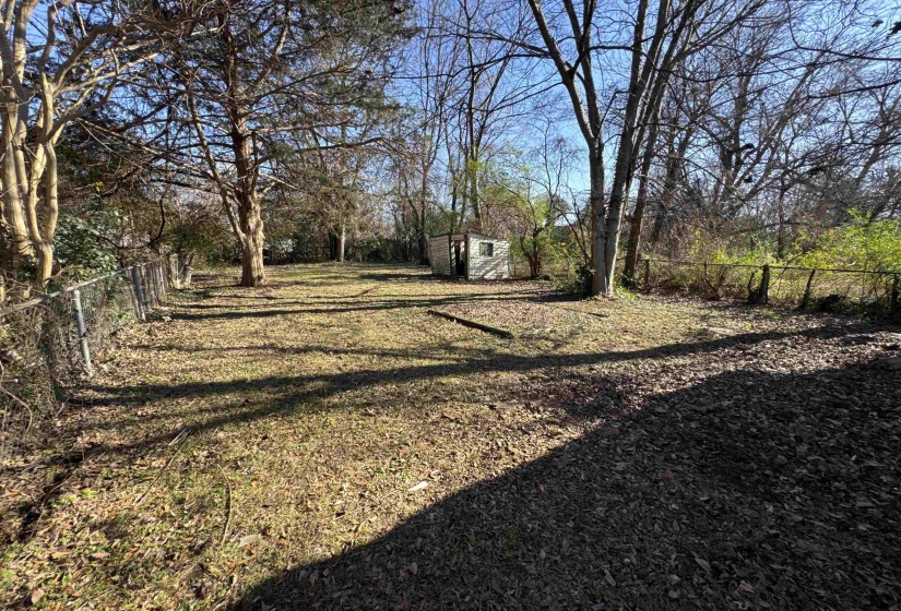Fenced backyard featuring a storage shed
