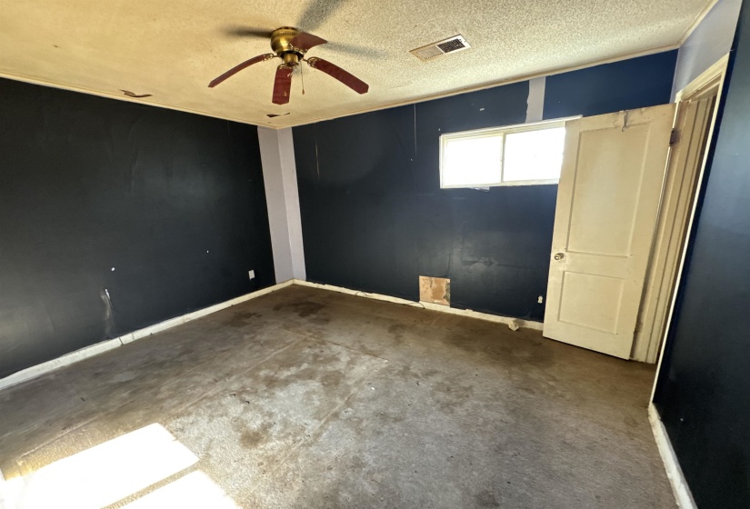 Unfurnished room with a textured ceiling and ceiling fan