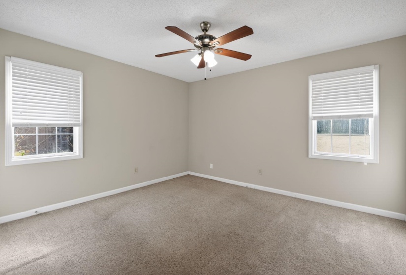 Unfurnished room with a textured ceiling, light colored carpet, and a ceiling fan