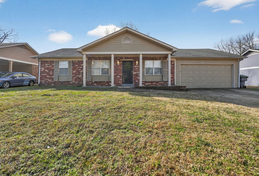 Ranch-style home featuring covered porch, a front yard, brick siding, asphalt driveway, and roof with shingles