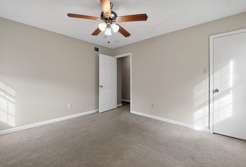 Unfurnished bedroom with a ceiling fan, carpet flooring, and a textured ceiling