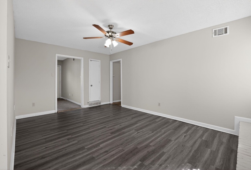 Unfurnished bedroom featuring dark wood finished floors, a ceiling fan, and a textured ceiling
