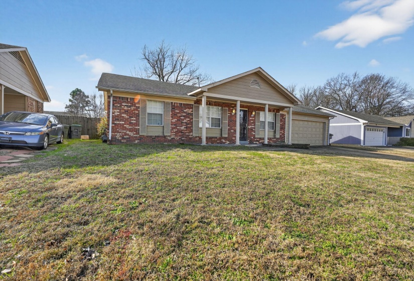 Ranch-style home featuring covered porch and brick siding