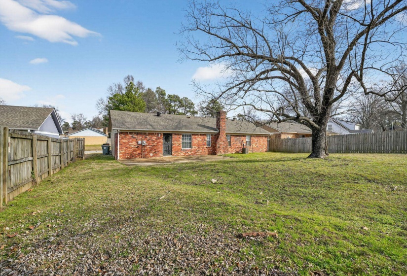 Back of house featuring a patio area, a fenced backyard, brick siding, and a chimney