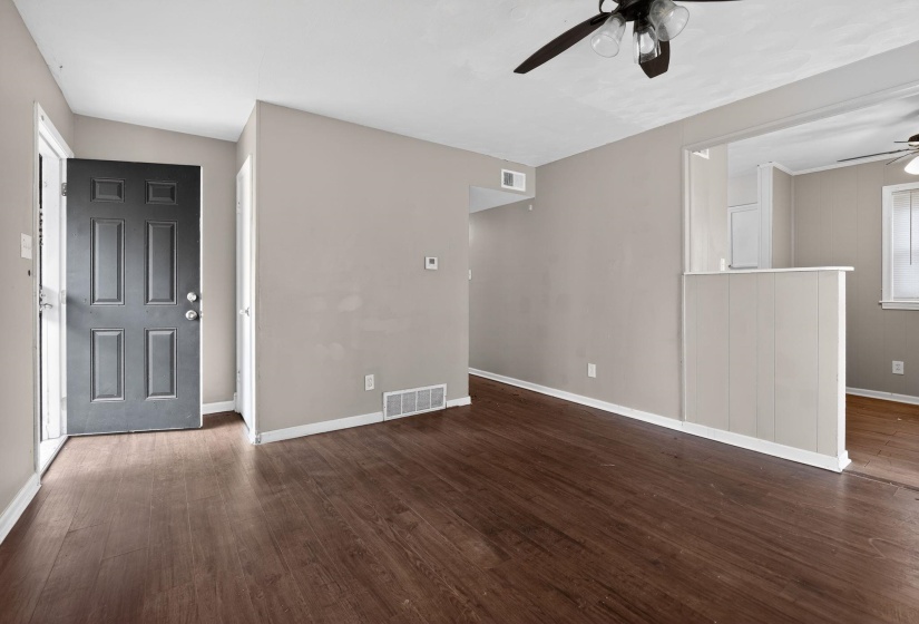 Unfurnished living room featuring dark wood-type flooring and ceiling fan