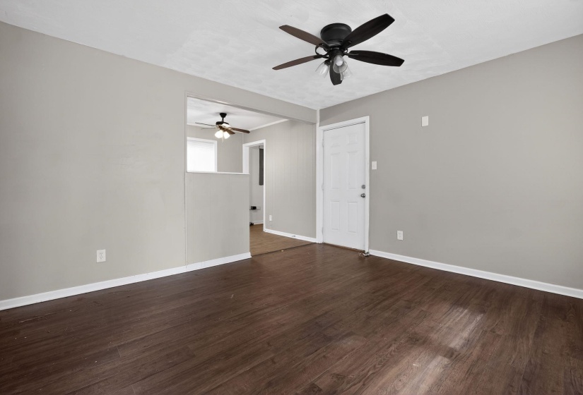 Empty room with dark wood-type flooring and a ceiling fan