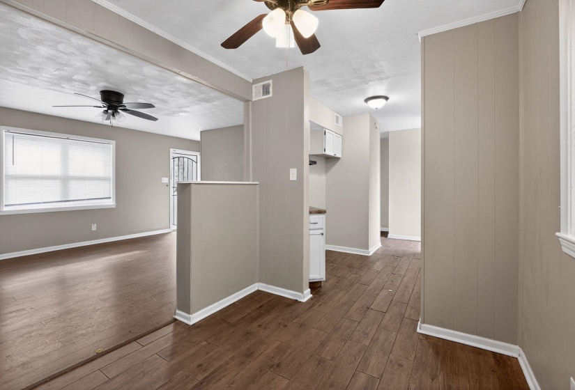 Empty room featuring ceiling fan and dark wood-style flooring