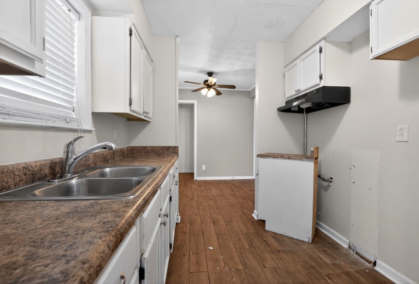 Kitchen featuring white cabinets, dark countertops, a ceiling fan, dark wood finished floors, and under cabinet range hood