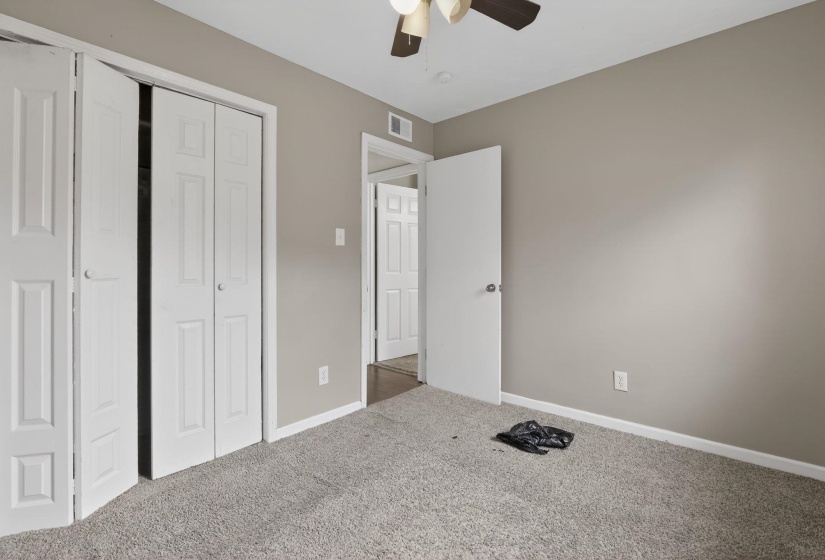 Unfurnished bedroom with a closet, carpet floors, and a ceiling fan