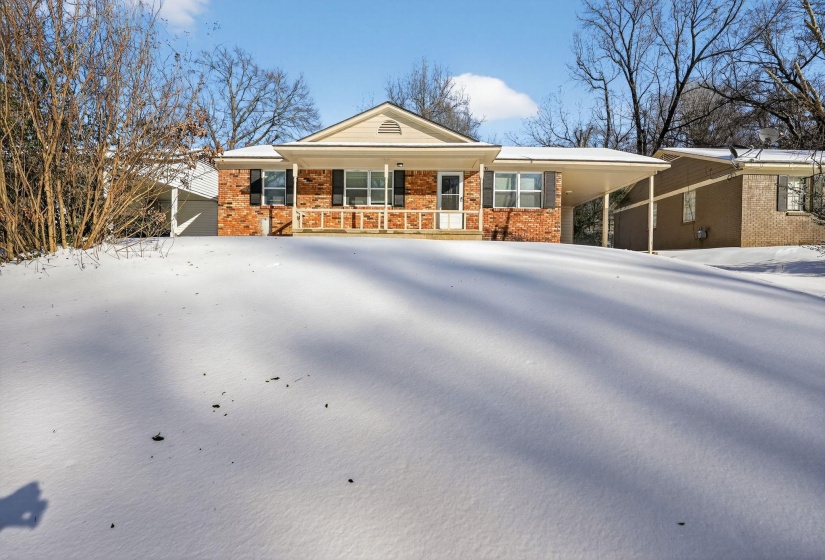 Ranch-style home with an attached carport, brick siding, and covered porch