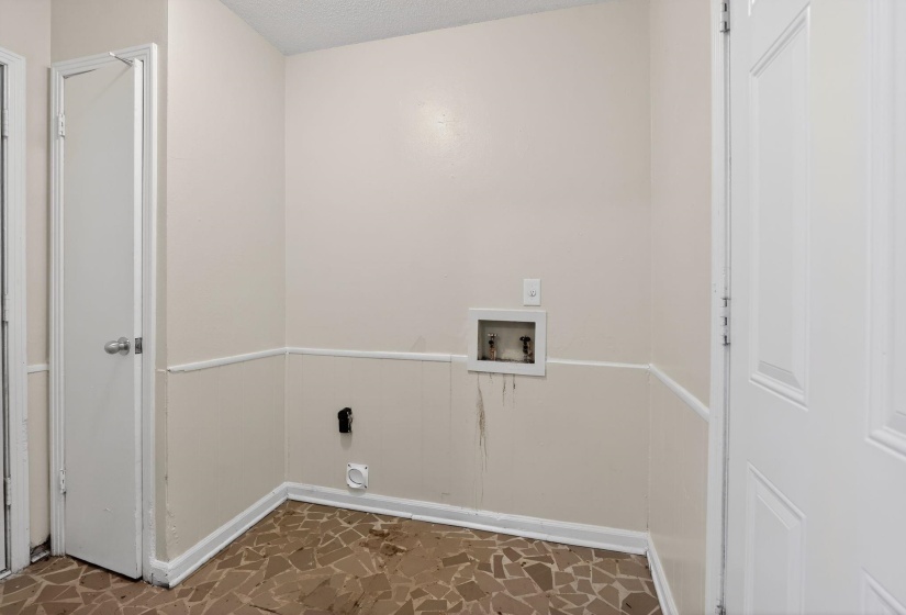 Laundry room featuring hookup for a washing machine, a wainscoted wall, and a textured ceiling