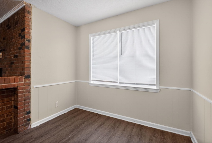 Empty room with wainscoting and dark wood-style floors