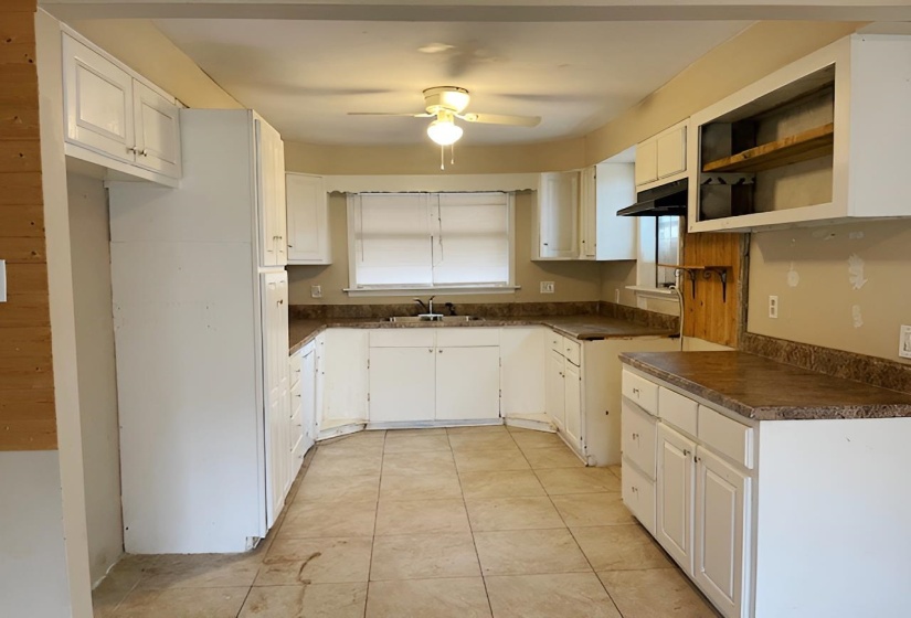 Kitchen with white cabinets, dark countertops, open shelves, and ceiling fan