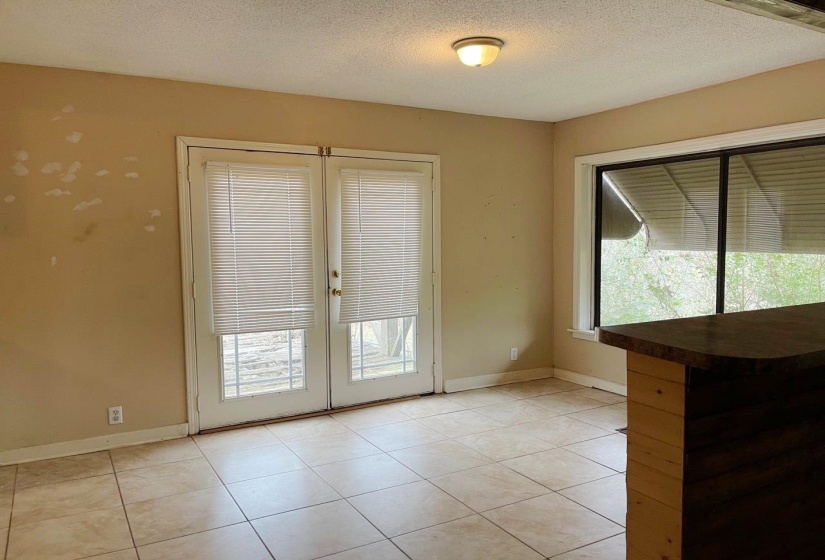 Doorway with french doors, a textured ceiling, and tile patterned floors