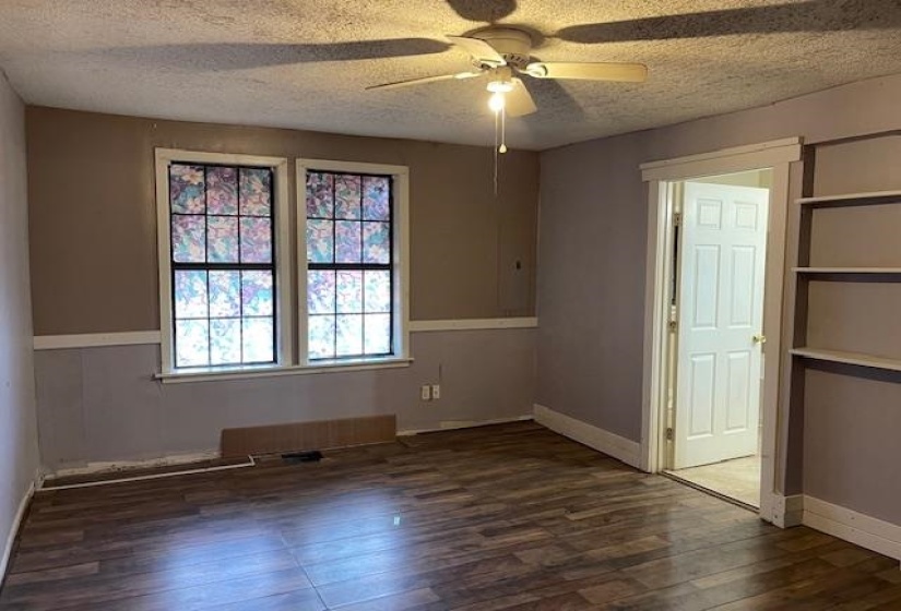 Spare room with dark wood-style flooring, a ceiling fan, and a textured ceiling