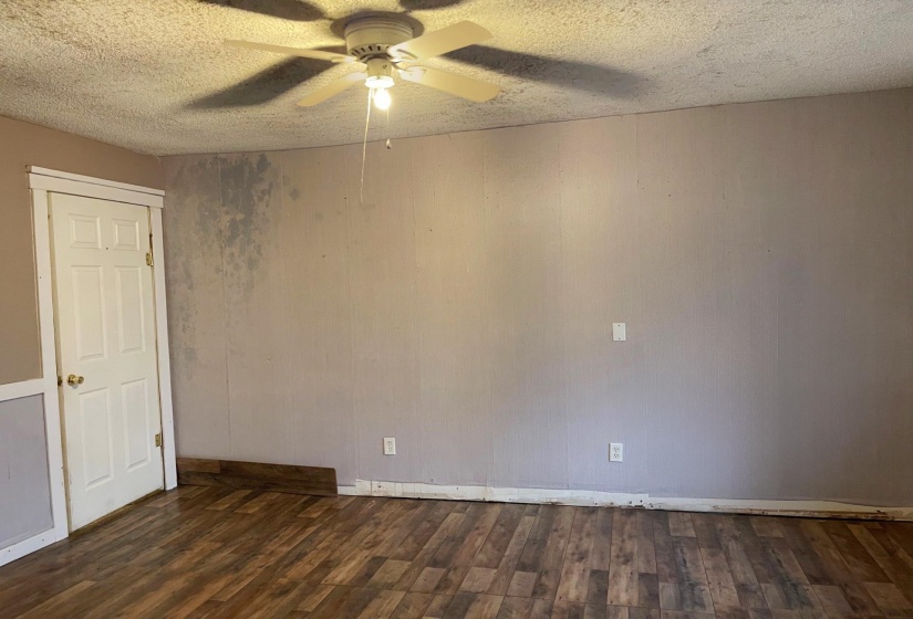 Empty room featuring a textured ceiling, dark wood finished floors, and ceiling fan