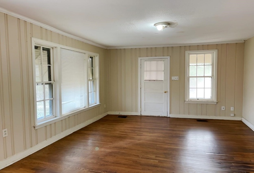 Spare room featuring dark wood finished floors and baseboards