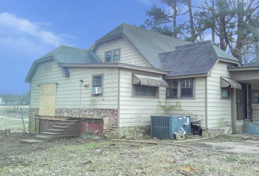 View of property exterior featuring a shingled roof and stone siding