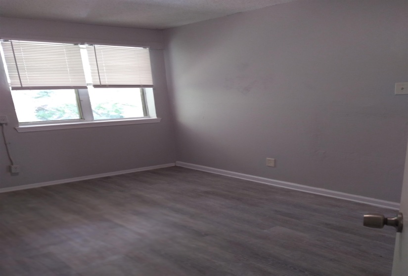 Empty room with dark wood finished floors and a textured ceiling