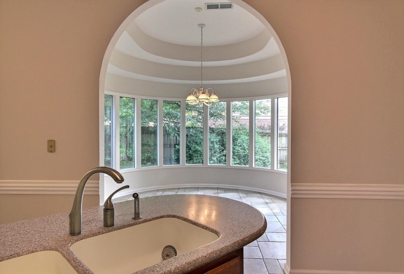 Dining room with a raised ceiling, plenty of natural light, and light tile patterned flooring