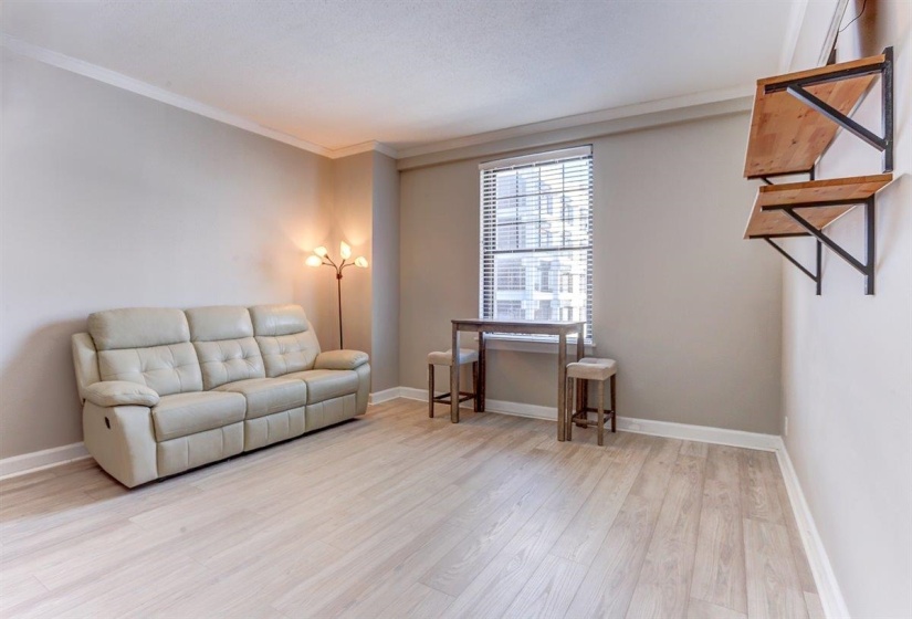 Living area featuring crown molding and light wood-style floors