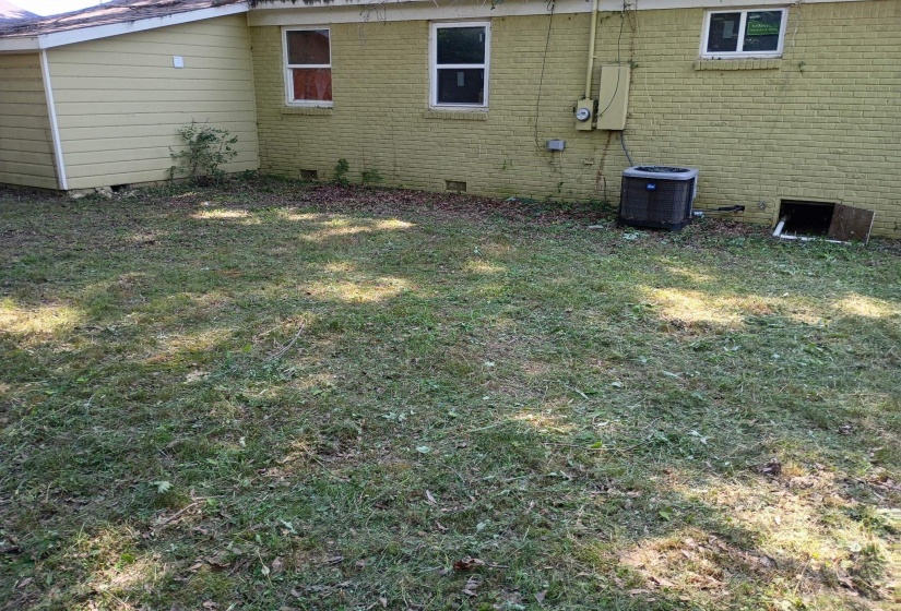 View of home's exterior featuring crawl space, brick siding, and a lawn