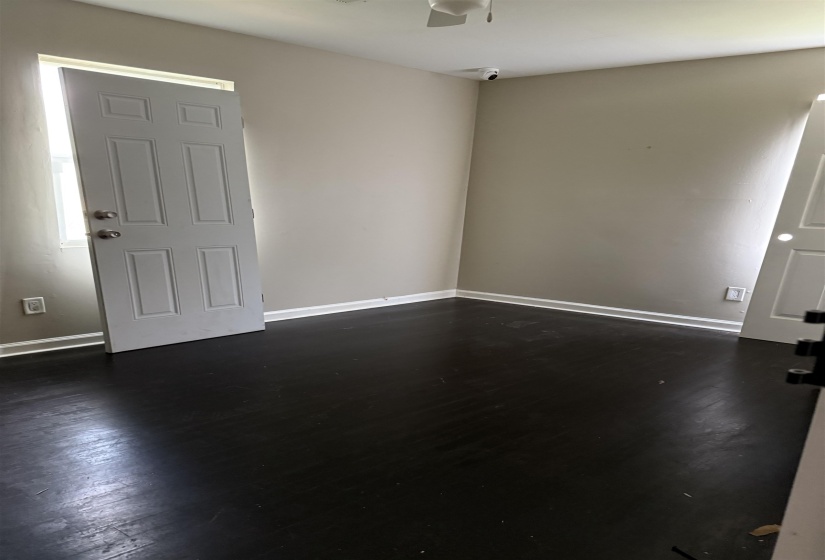 Spare room with dark wood-style flooring and ceiling fan