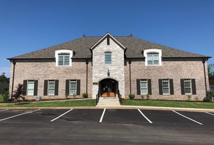 View of building exterior with uncovered parking