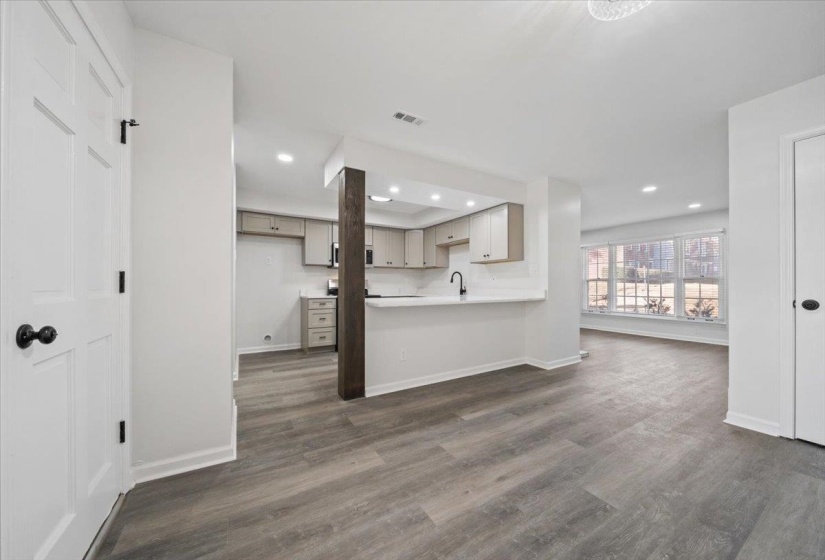 Unfurnished living room with dark wood-type flooring and recessed lighting